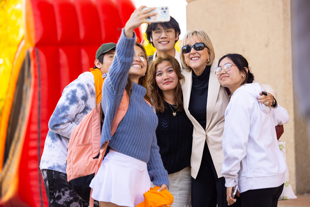 Chancellor Donde Plowman takes a selfie with students during the Homecoming Kick-Off and Pep Rally at HSS Plaza.